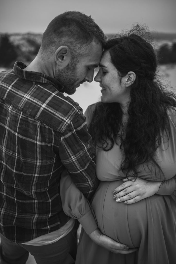 Special moments felt during this Oregon Coast maternity session in black and white image of young couple embracing this in-between phase