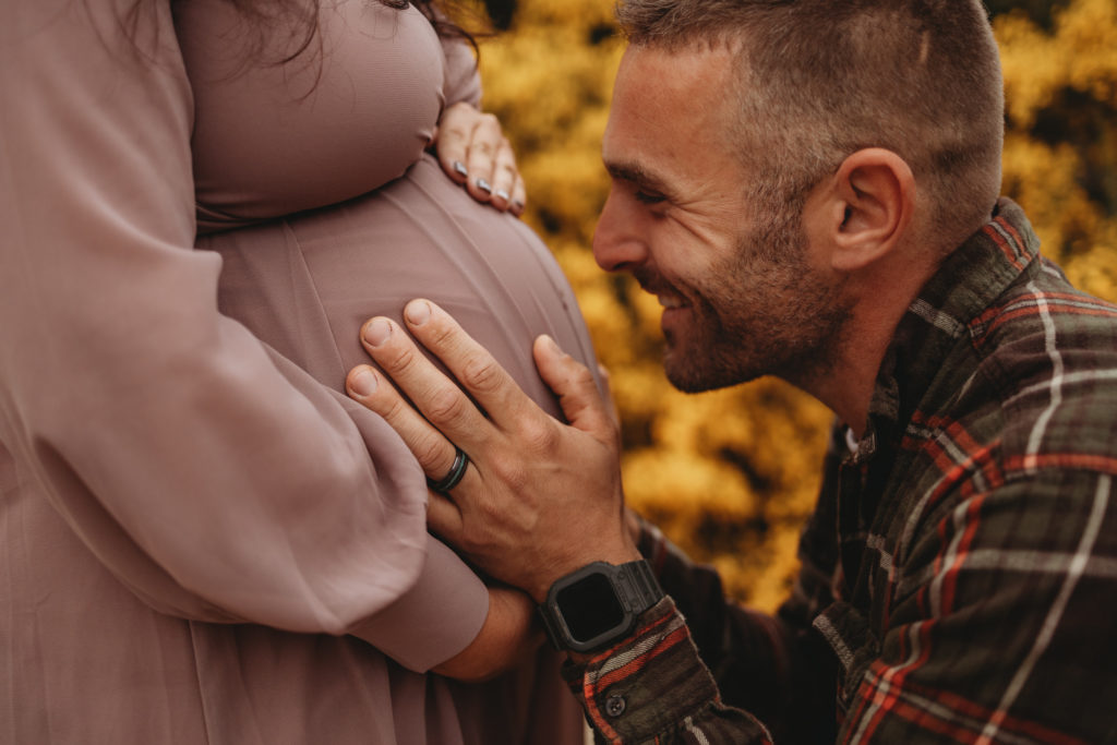 Husband kissing his wives pregnancy belly during an Oregon Coast maternity session