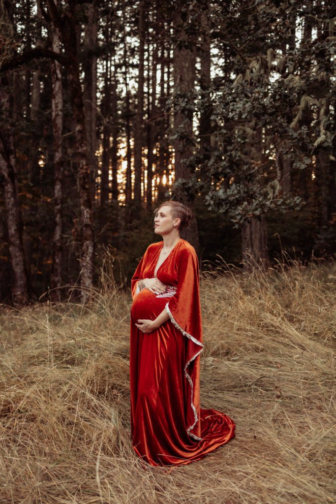 Beautiful pregnant woman in red gown during maternity photos with Eugene family photographer 