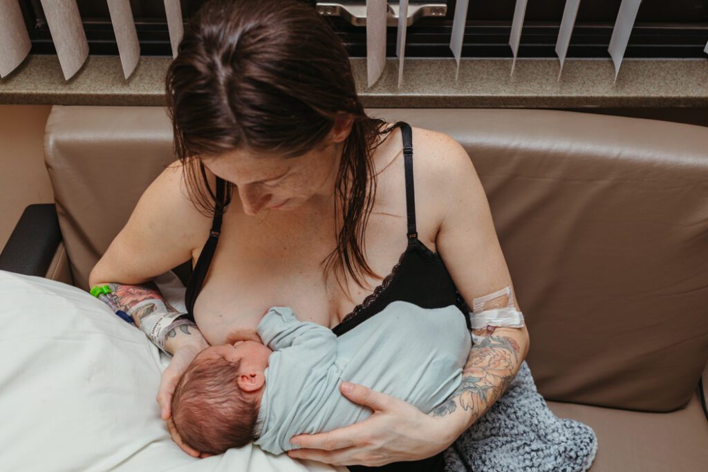 mom breastfeeding just born baby during hospital newborn photos